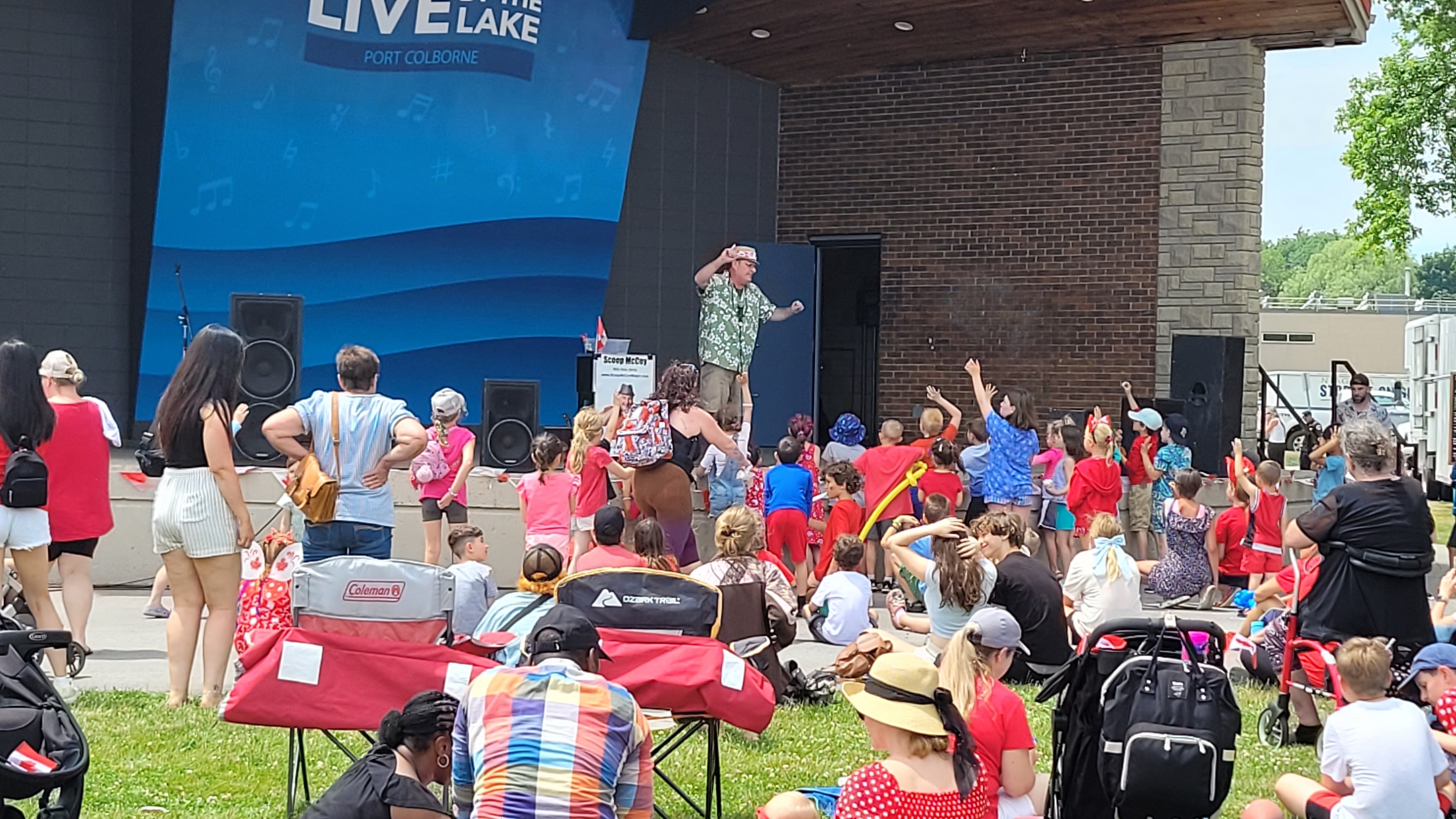 Large crowd at an outdoor Canada Day festival watching Scoop McCoy perform