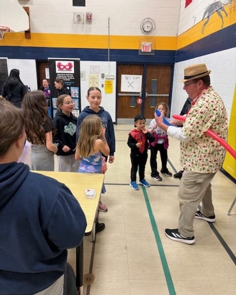 Scoop performing in a school gymnasium